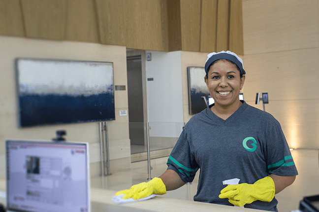 Bom fornecedor de facilities: profissional da Guima Conseco realizando limpeza de balcão em ambiente corporativo, garantindo organização, bem-estar e qualidade nos serviços.