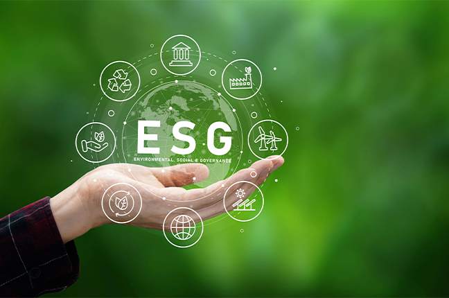 Mão segurando ícones de ESG em fundo verde representando metas ambientais na operação predial